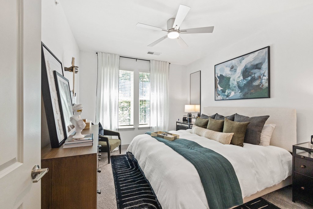 a bedroom with a large bed and a ceiling fan