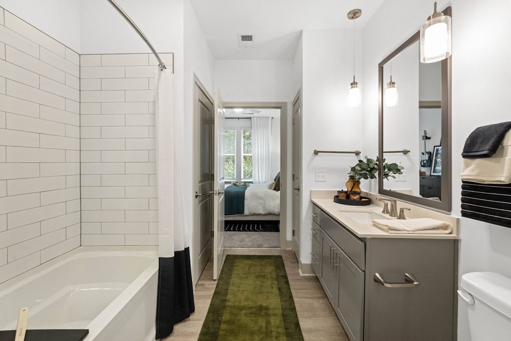 a white bathroom with a tub and a sink and a mirror