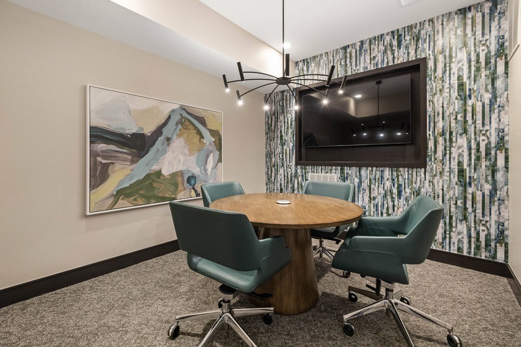 a conference room with a table and chairs and a television