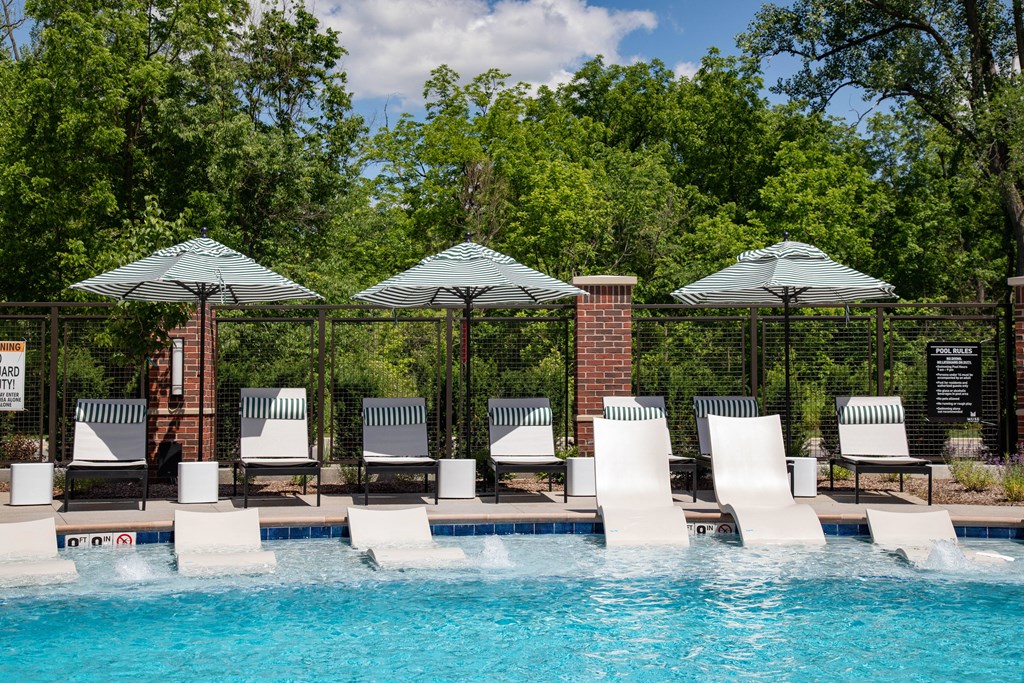 a swimming pool with chairs and umbrellas next to it