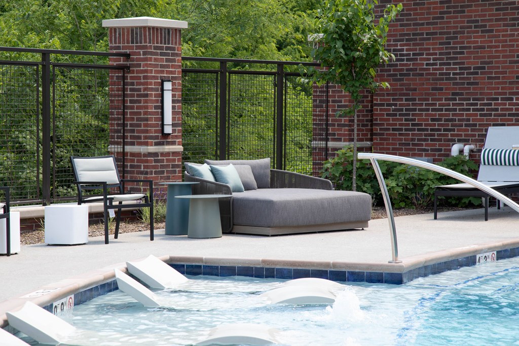 a swimming pool with a couch and chairs next to a pool