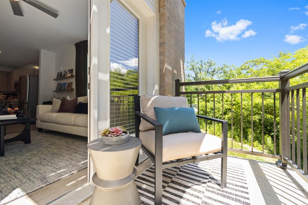 a patio with a chair and a table on a balcony