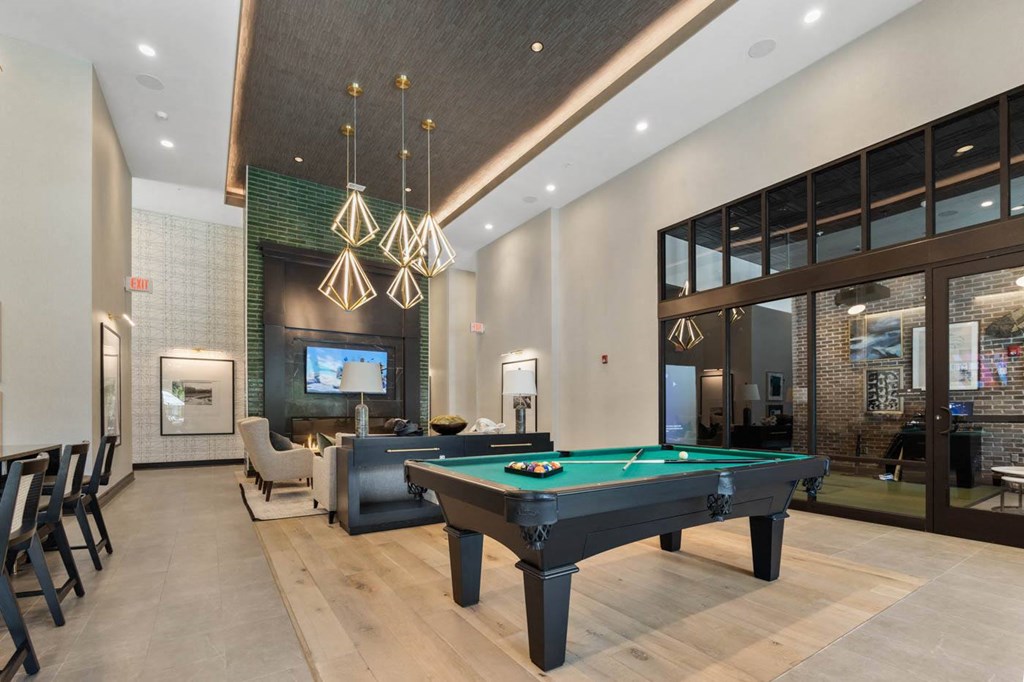 a pool table in the lobby of a clubhouse with a tv