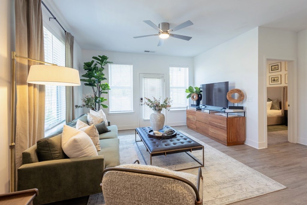 Living room with TV console and view into bedroom at Nook Nine apartments