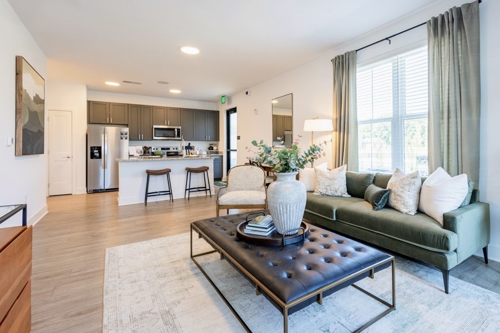 Apartment living room with stylish furniture and view of open kitchen at Nook Nine