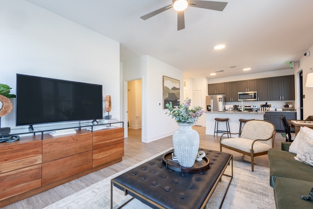 TV setup with wood console and open view to kitchen and bar seating at Nook Nine