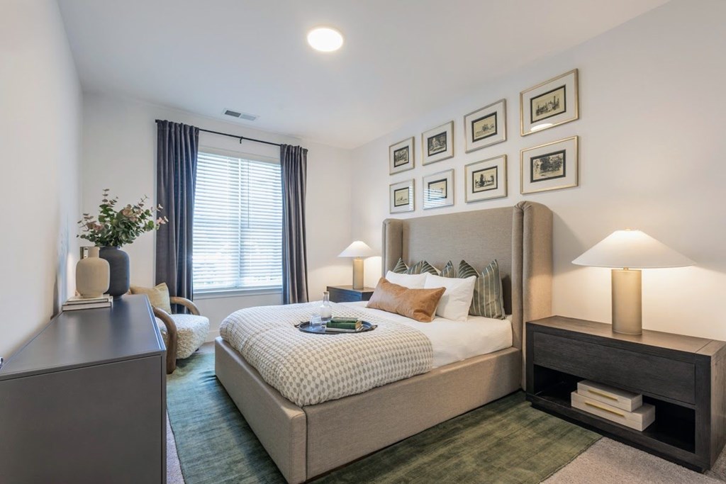 Stylish bedroom with upholstered bed, framed artwork, and natural light at Nook Nine