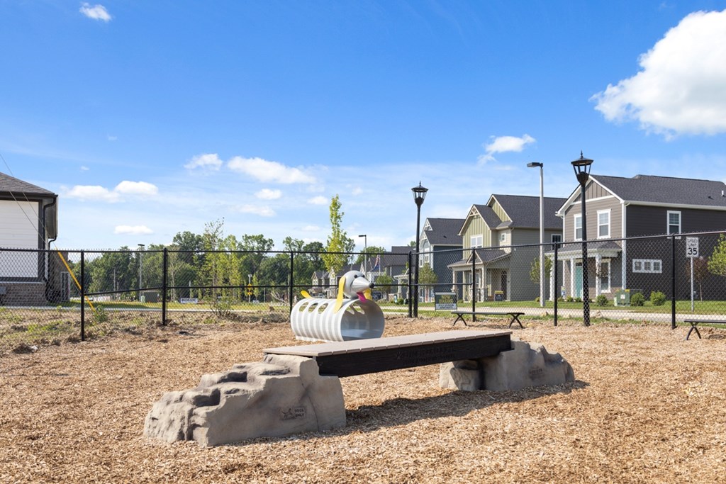 A playground with a slide and a bench in the foreground.