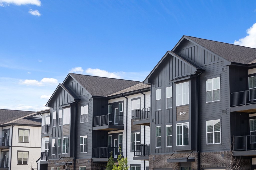 Apartment buildings with balconies and a clear blue sky above.