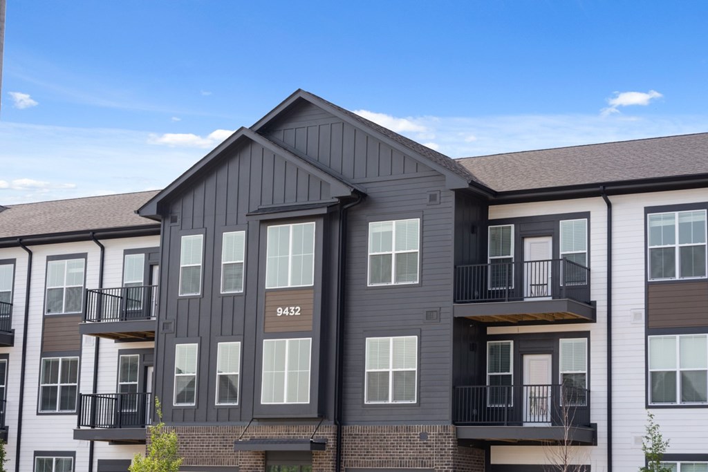 A modern apartment building with balconies and a clear blue sky.