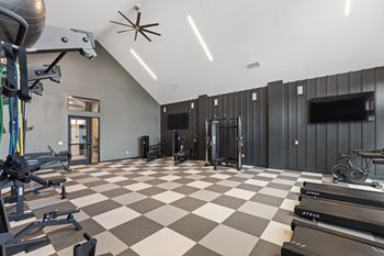 Fitness center with treadmills and weight machines  at Montage West Lafayette Apartments, Indiana