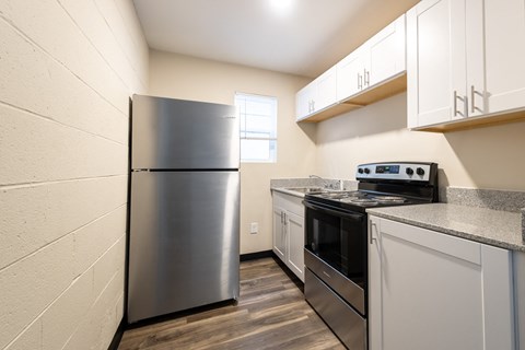 A kitchen with a stainless steel refrigerator and stove.