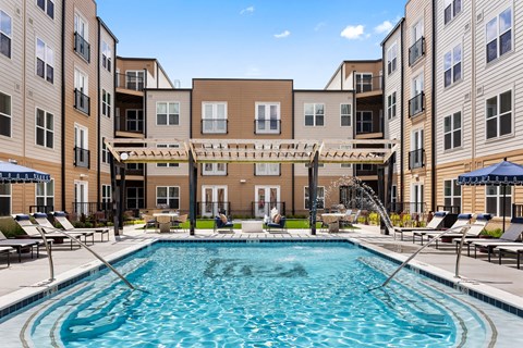 A large, inviting swimming pool at the center of the Portrait Midtown apartment community courtyard.