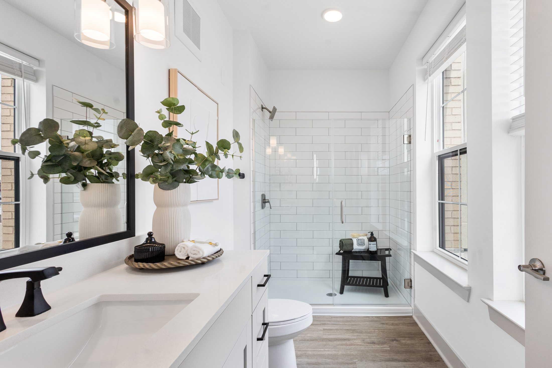 A white bathroom with a white sink and a white toilet.