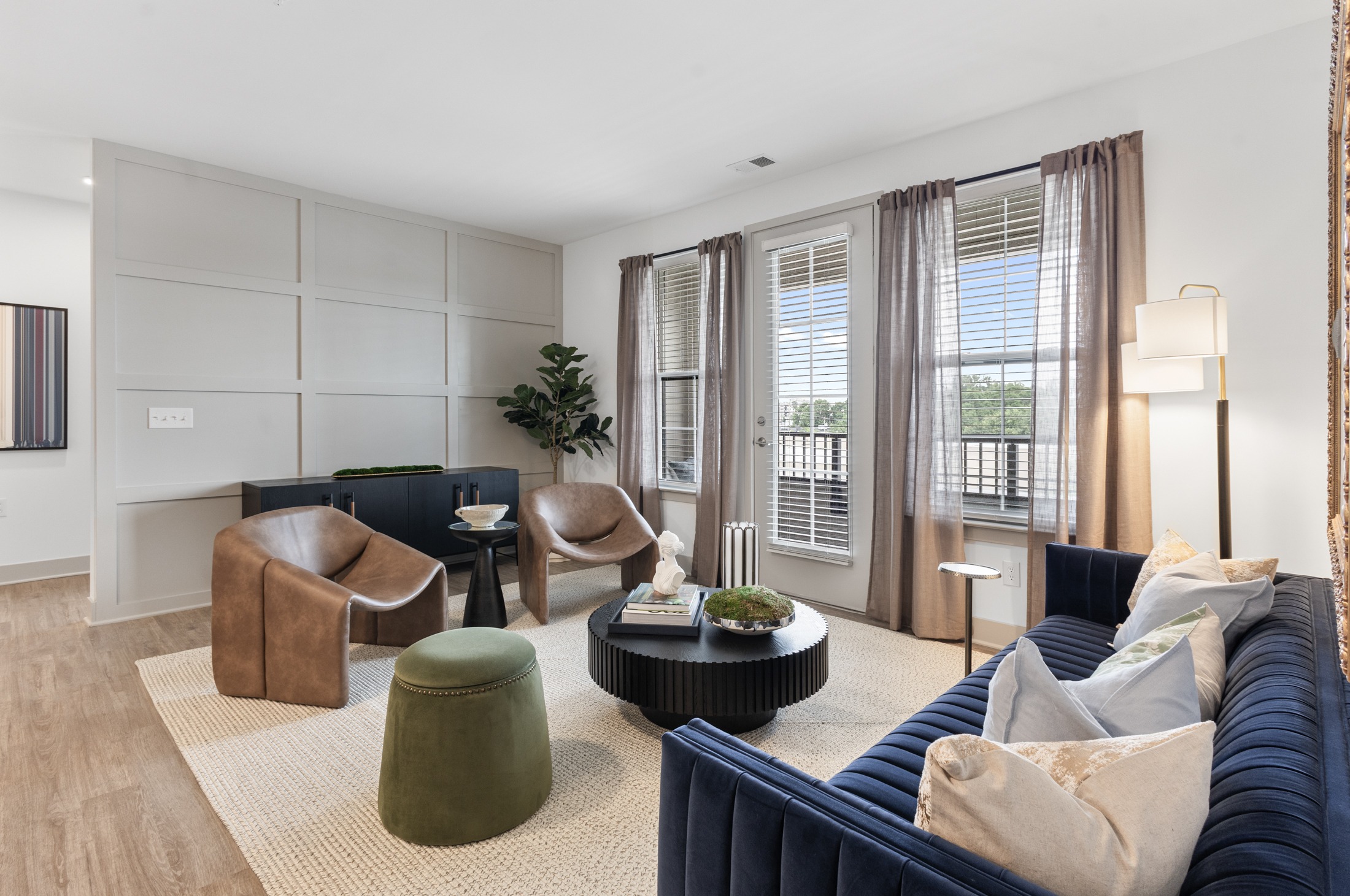 A living room with a blue couch and a green ottoman.