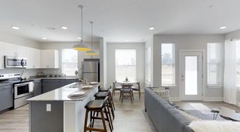 A modern kitchen with a large island and a dining area at Echo Park at Perry Crossing Apartments, Plainfield, 46168