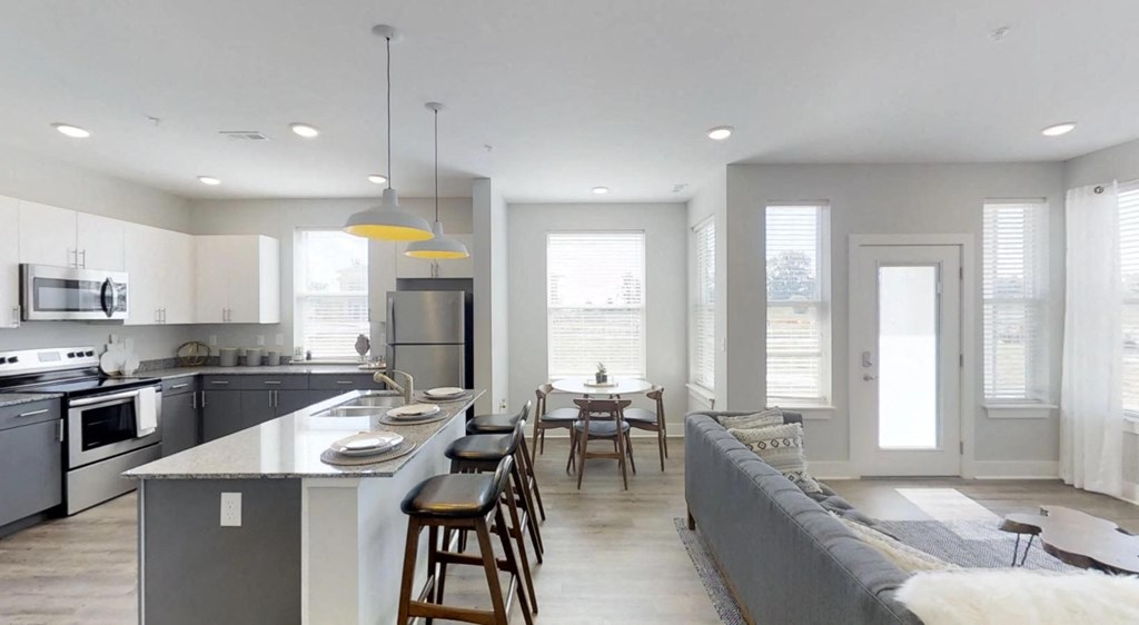 an open kitchen and living room with a table and chairs at Echo Park at Perry Crossing Apartments, Plainfield, Indiana