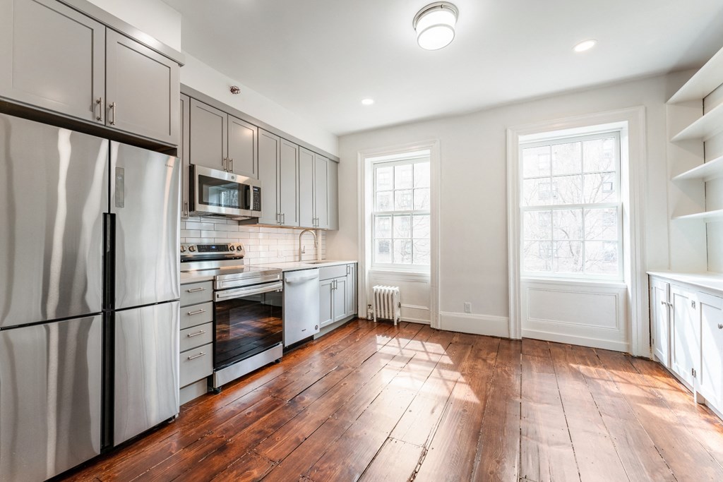 a kitchen with gray cabinets and white appliances