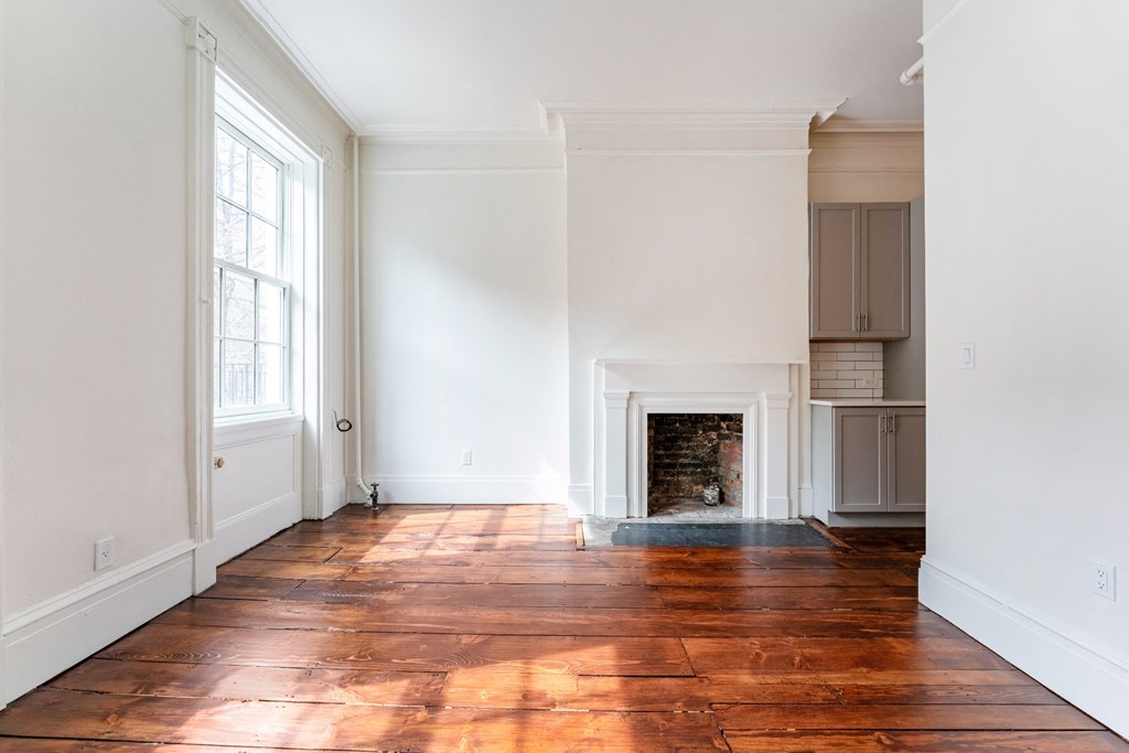 a living room with white walls and a fireplace