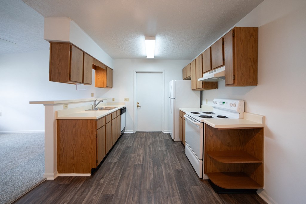 a kitchen with wood flooring and white appliances