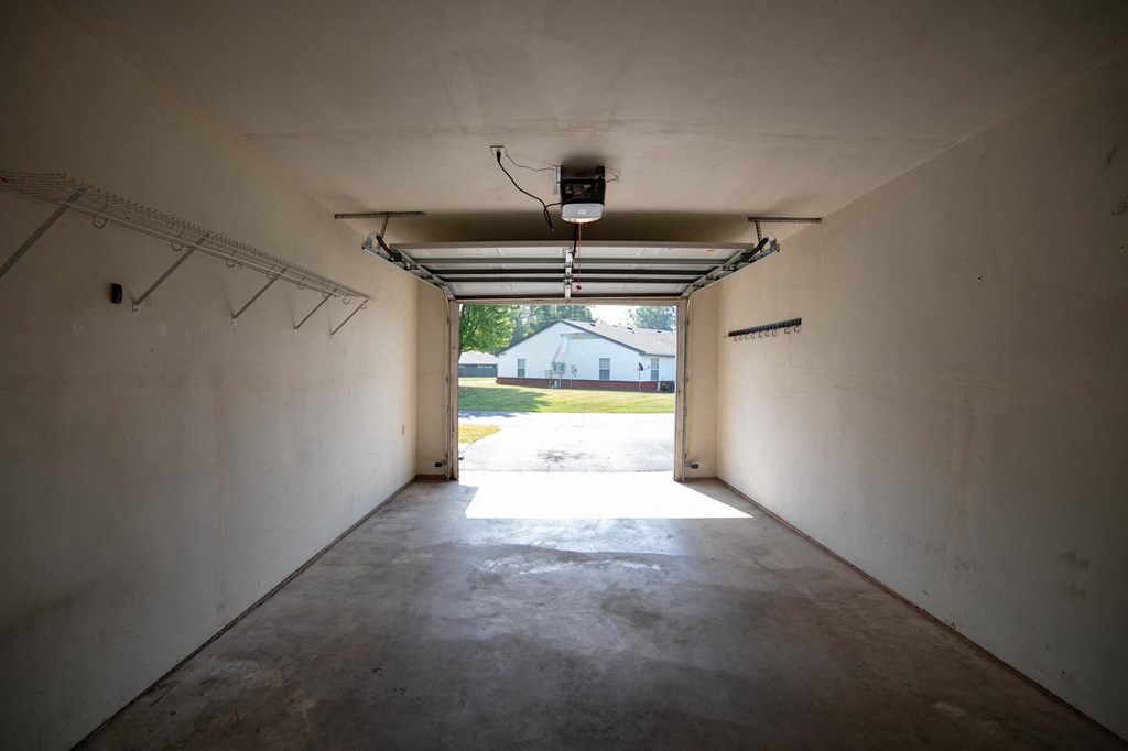 an empty garage with a white house in the background