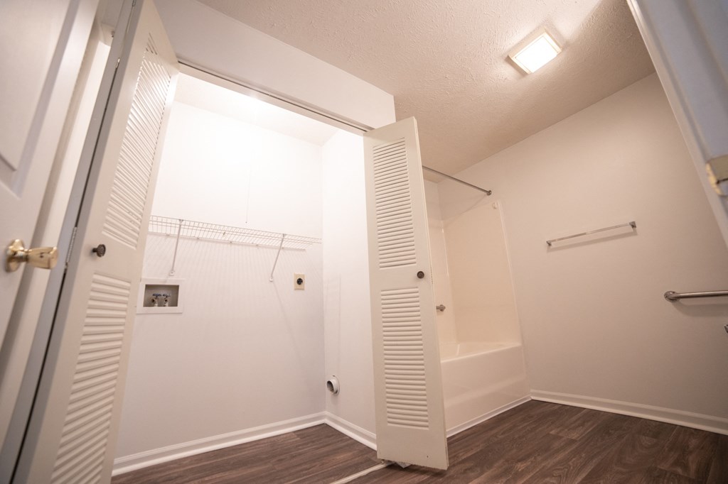 a bedroom with a medium sized closet and a bathtub