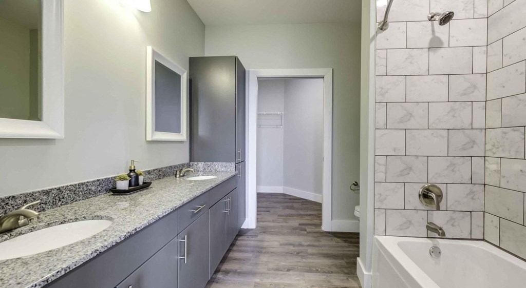 a bathroom with two sinks and a tub and a shower at Echo Park at Perry Crossing Apartments, Plainfield, IN