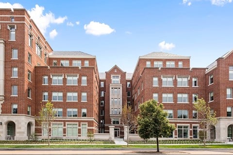 A large red brick building with a tree in front.