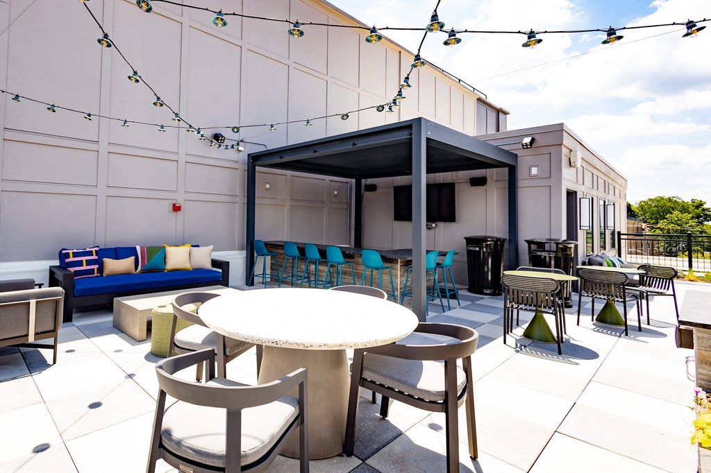 a patio area with tables and chairs and a television