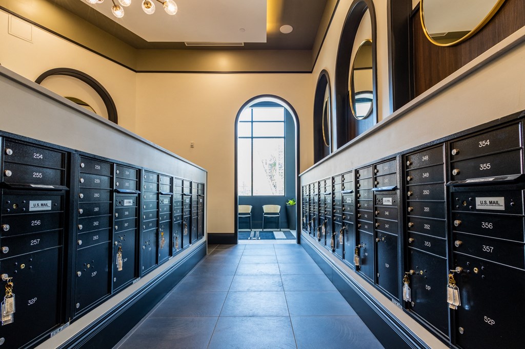 a row of lockers in a hallway with a large window at the end of the hallway