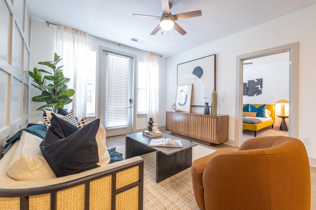 a living room with a couch and a chair and a ceiling fan