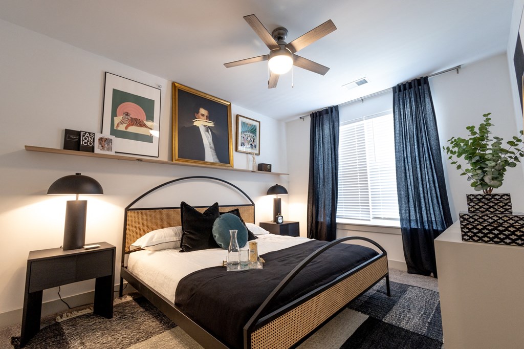 a bedroom with a large bed and a ceiling fan a bedroom with a large bed and a ceiling fan