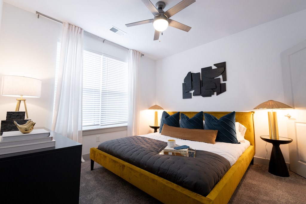 a bedroom with a large bed and a ceiling fan