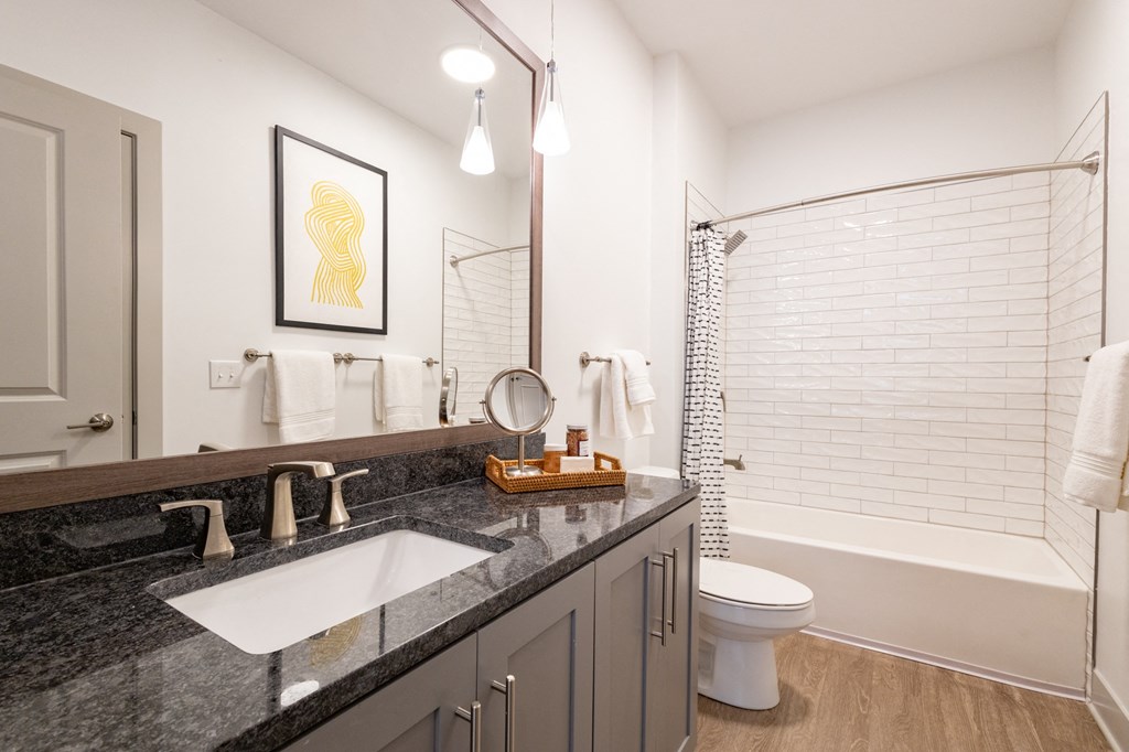 a bathroom with a gray vanity and a white bathtub