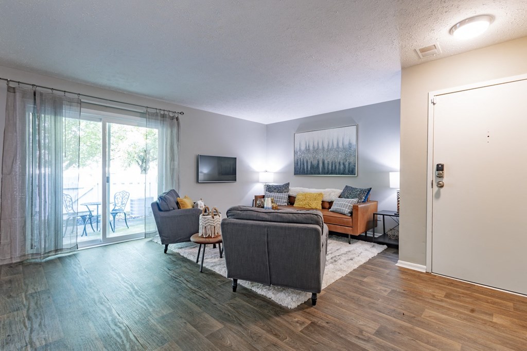 a living room with a couch and chairs and a tv