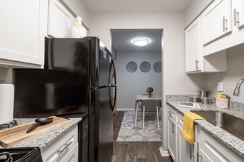 a kitchen with white cabinets and a black refrigerator