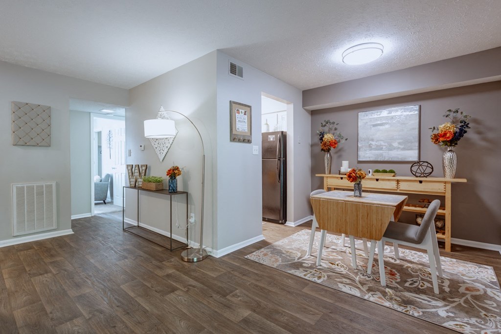 a dining room and kitchen with a table and chairs and a refrigerator