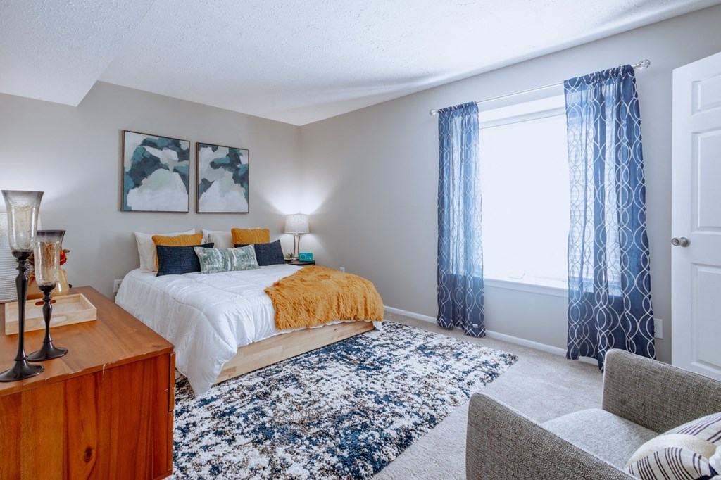 a bedroom with a bed and a window with blue curtains