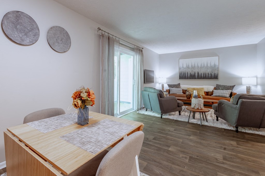 a living room and dining room with a table and chairs