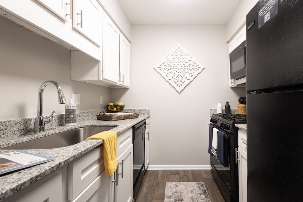 a kitchen with granite counter tops and black appliances