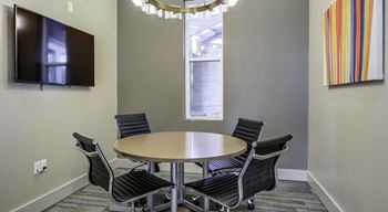 A conference room with a table, chairs, and a television. at Echo Park at Perry Crossing Apartments, Indiana