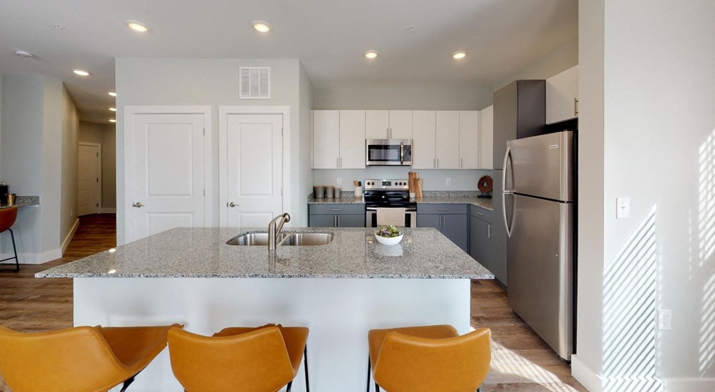 a kitchen with a granite counter top and a stainless steel refrigerator at Echo Park at Perry Crossing Apartments, Plainfield, Indiana