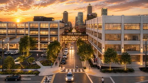 A sunset view of a city street with cars and people.