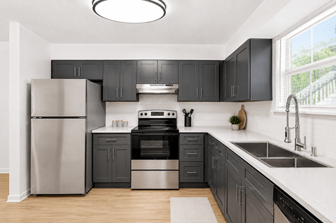 A modern kitchen with black cabinets and stainless steel appliances.