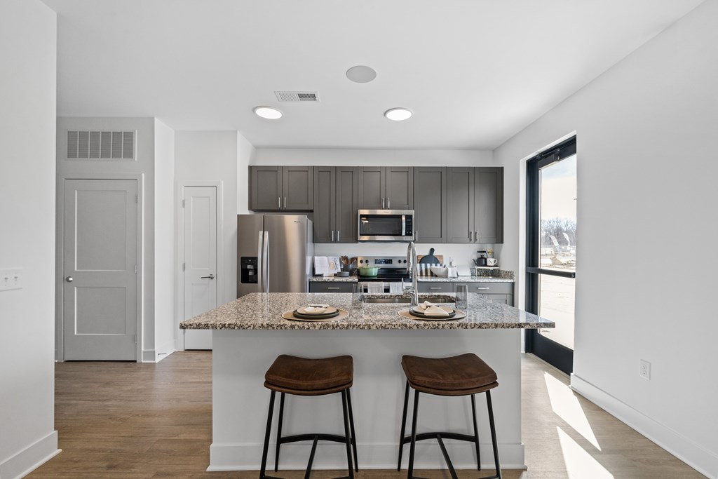 Modern kitchen at Nook Nine with granite island, stainless steel appliances, and sleek cabinetry.
