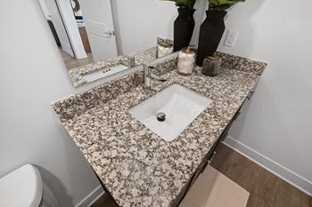 Elegant bathroom vanity at Nook Nine with granite countertops, modern fixtures, and ample storage.