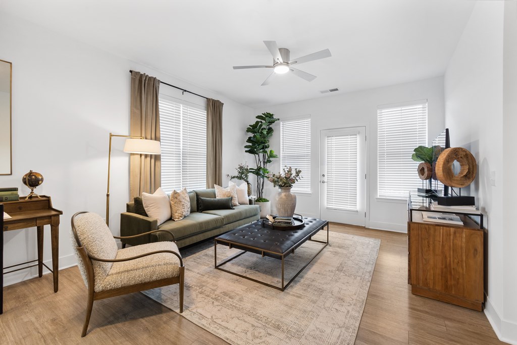 Spacious living room at Nook Nine with modern decor, wood-style flooring, and abundant natural light