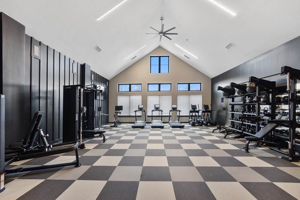 Bright fitness center at Nook Nine with cardio, strength training, and high ceilings for an open feel.