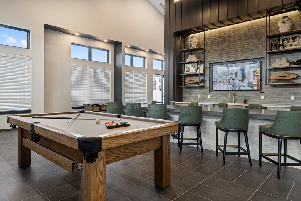 Luxury clubhouse at Nook Nine with a billiards table, bar seating, and modern decor.