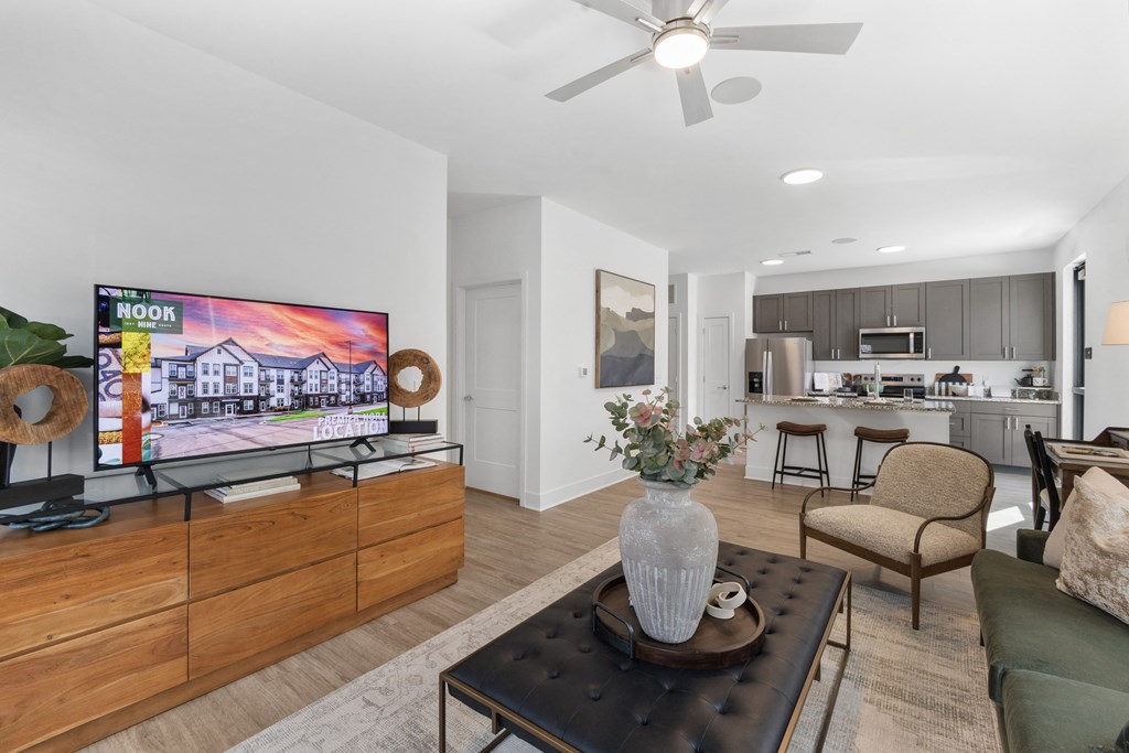 Stylish open-concept living at Nook Nine with modern decor, wood-style flooring, and gourmet kitchen.